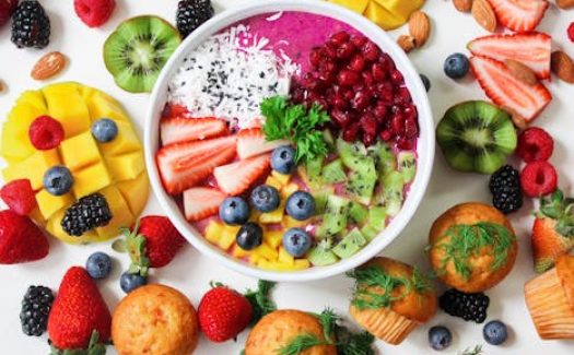 Vibrant smoothie bowl topped with assorted fresh fruits and muffins, perfect for a healthy snack.